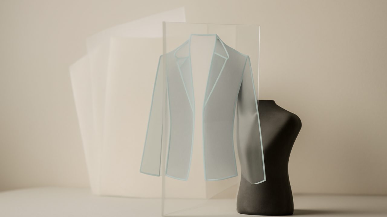 A lifted acrylic clothing overlay revealing the chosen look on a studio mannequin