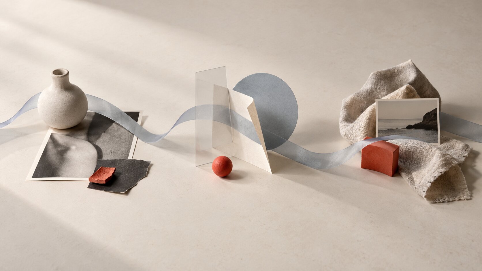A translucent blue-gray ribbon passes through several different editorial compositions, visually connecting them into one recognizable creative system.